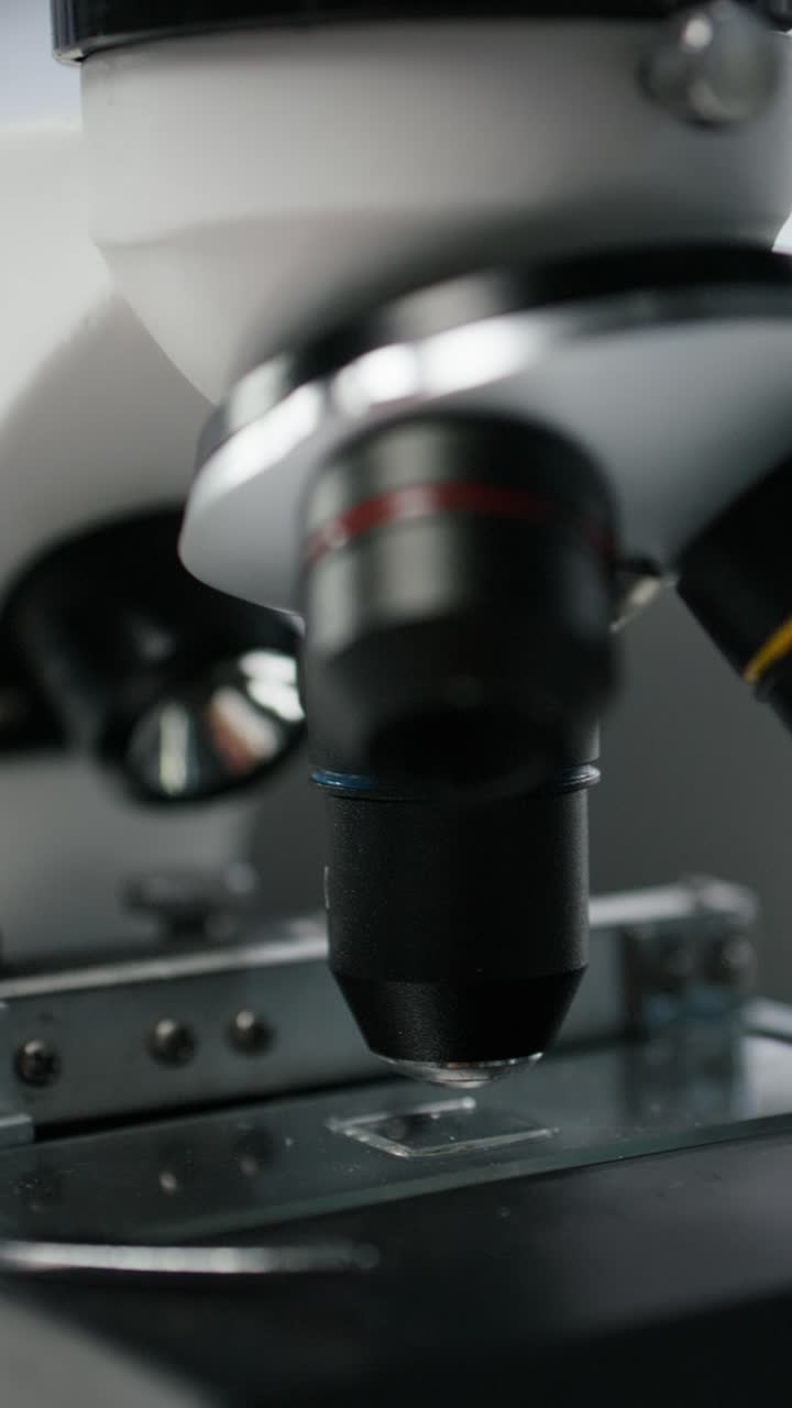 Vertical video Close up of microscope on workbench in sterile empty hospital laboratory