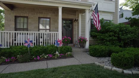 Kamera-Driftet-Vor-Einem-Schönen-Vorstadthaus-Mit-Amerikanischer-Flagge-Und-Patriotischen-Dekorationen