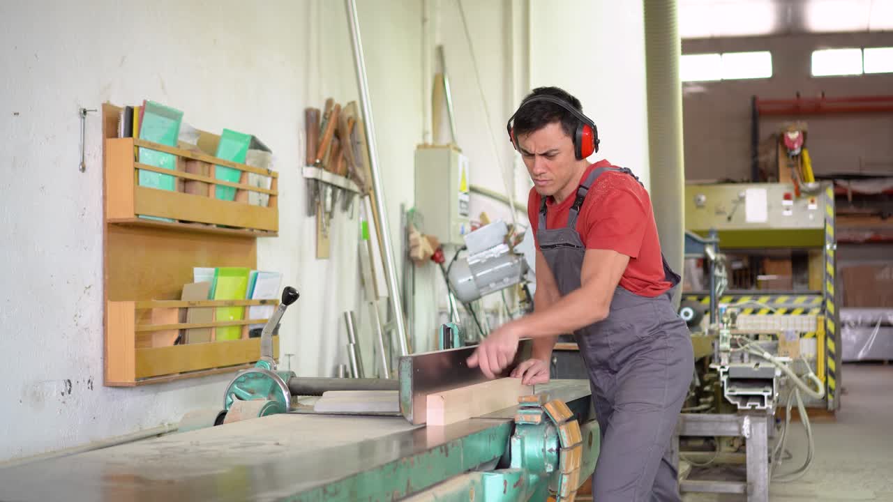 Man working with wood on a planing machine in a workshop