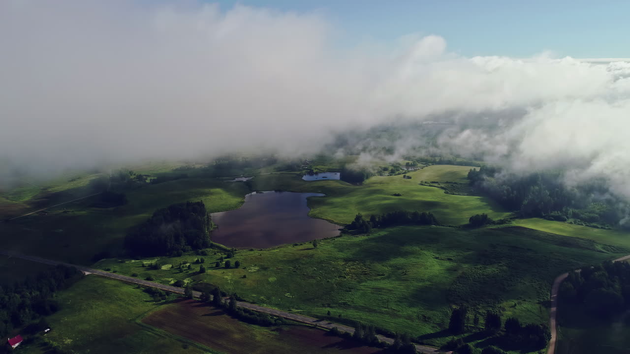 vuelo de drones entre nubes sobre un paisaje rural verde