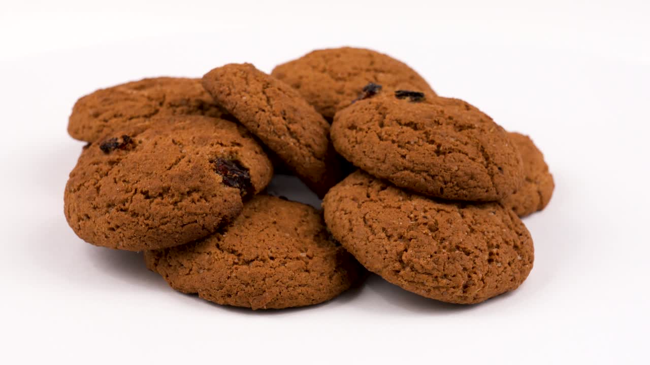 Havermoutkoekjes in landelijke stijl met rozijnen. Draaiend. Geïsoleerd op wit