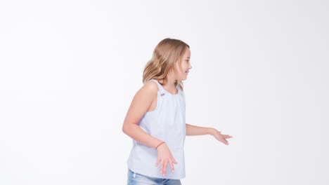 girl walks into shot and poses against white studio background