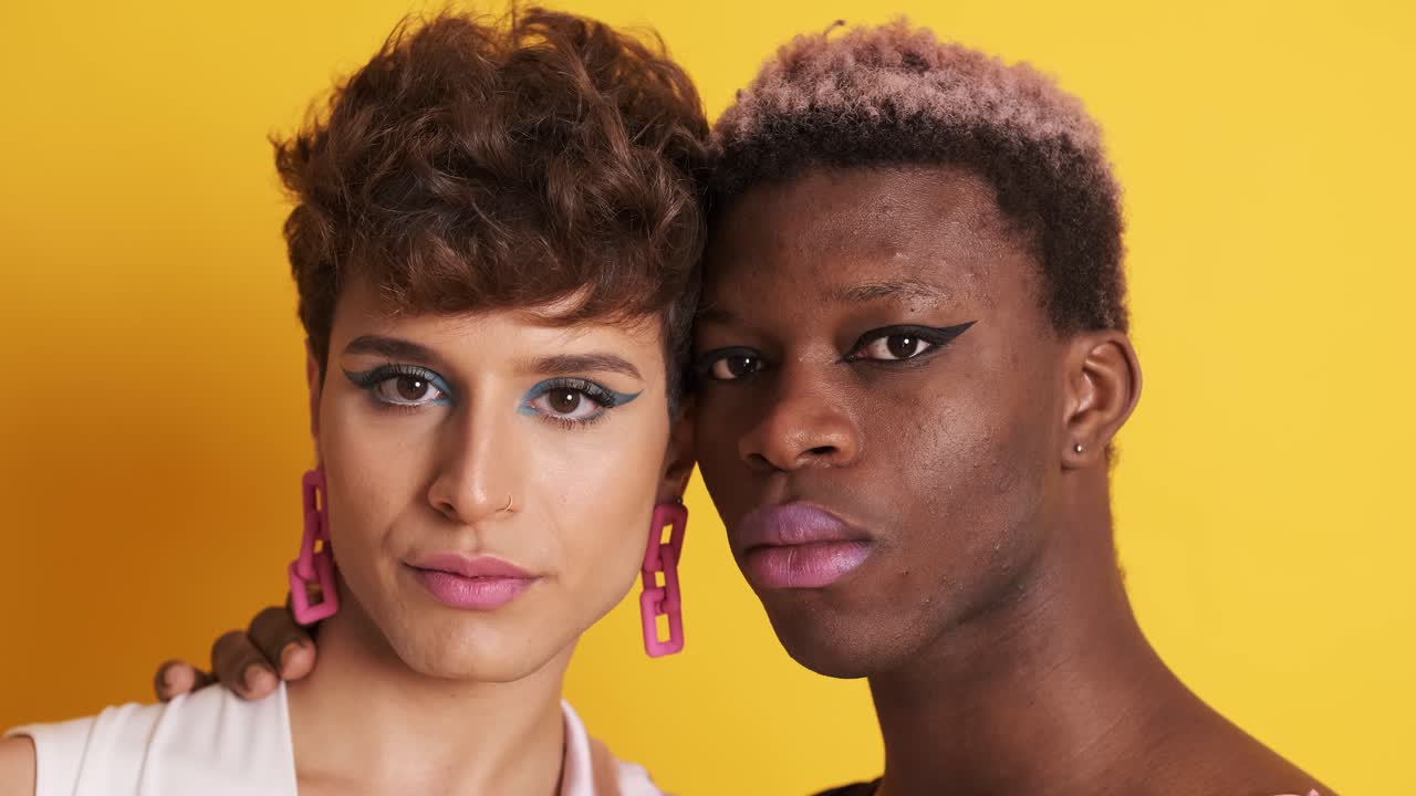 Two multiethnic transgender men looking at the camera with a serious look