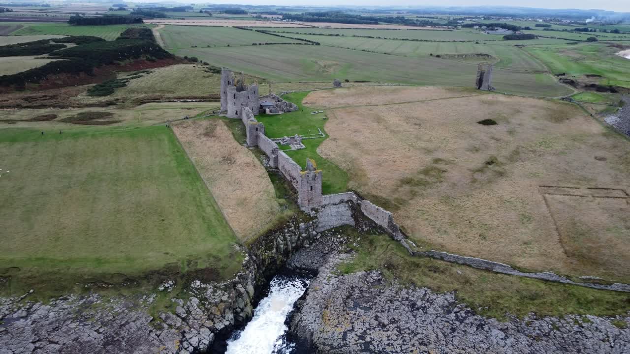 castillo de dunstanburgh - alejar toma de seguimiento aéreo