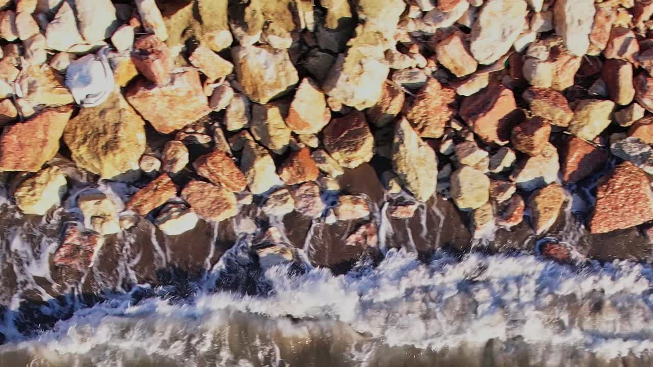 Bølger skvulper mod klipper langs kysten af Rhodos, Grækenland om dagen
