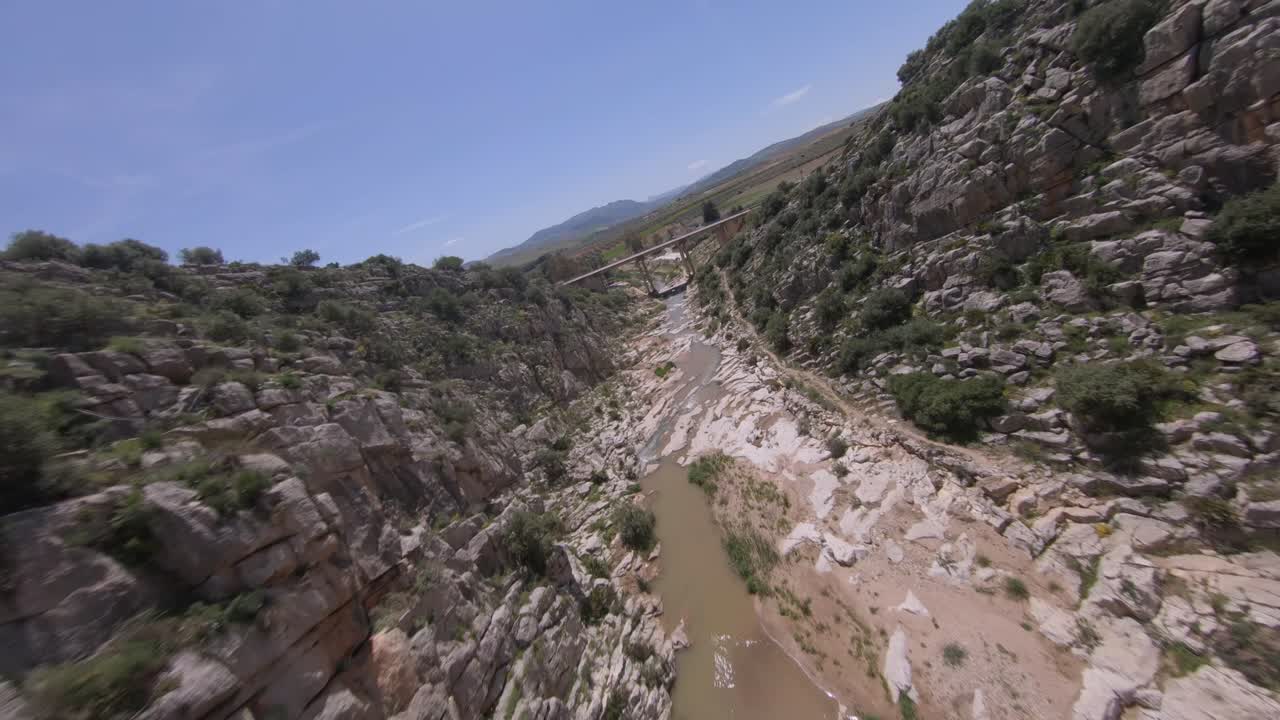 fpv drone vuela cerca de la pared de roca escarpada en el estrecho desfiladero del cañón del río