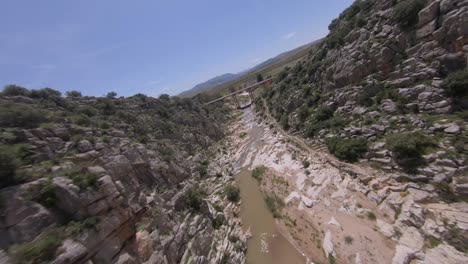 Fpv-drohne-Fliegt-In-Der-Nähe-Der-Schroffen-Felswand-In-Der-Engen-Schlucht-Des-Flussschluchts