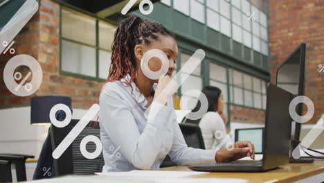 mujer de negocios afroamericana feliz con computadora portátil en el trabajo en la oficina