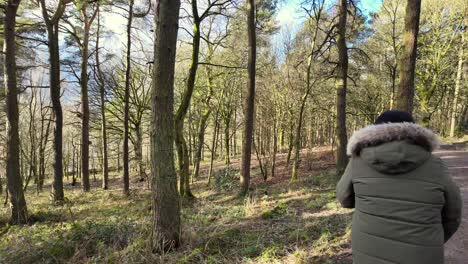 young boy and his mother walking on a rural footpath on a day out in the forest woodlands