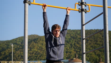 man doing pull-ups at outdoor fitness park