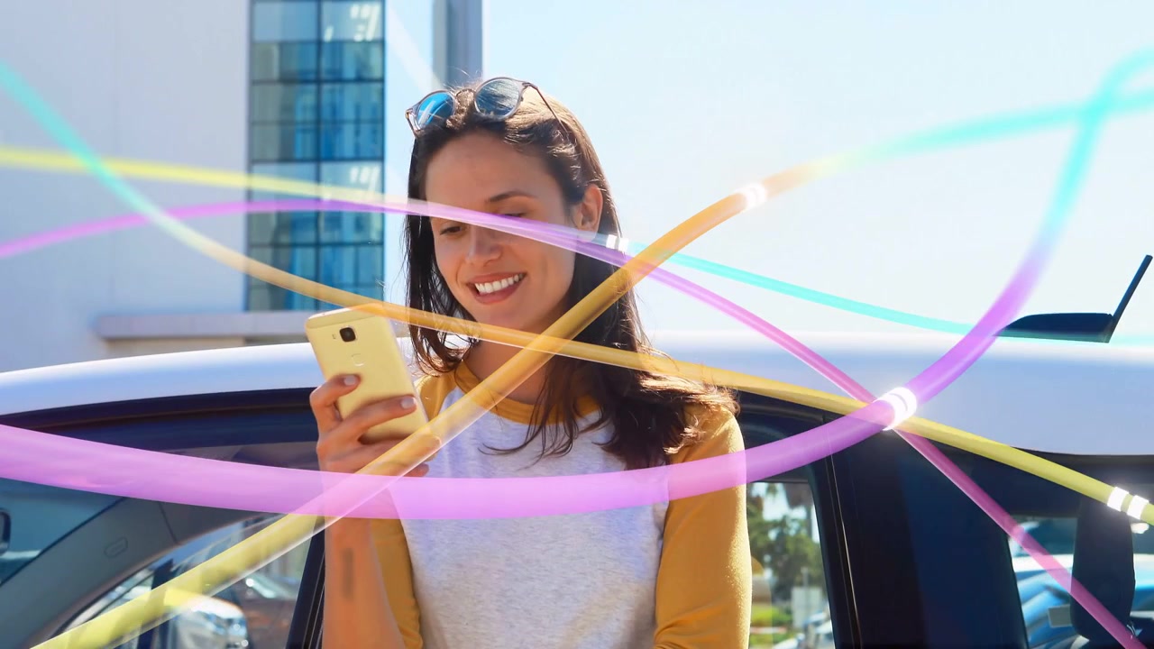 Mujer usando el teléfono apoyada en un coche, generando cintas que muestran una publicación de marketing, sonriendo.