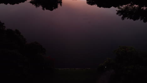 Top-view-above-the-Temple-to-Music-in-Roger-Williams-Park,-tilting-towards-a-sunset-over-the-lakes