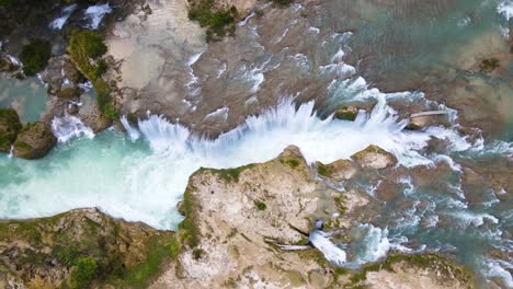 toma aérea de arriba hacia abajo de la cascada que cae sobre el cañón, viaje a méxico