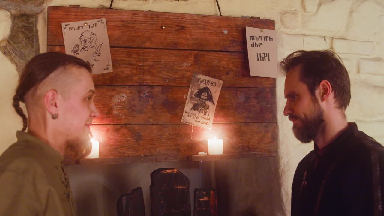 남자는 술집의 게시판에서 친구와 함께 대인간을 죽이는 것을 선택합니다. 방랑자들은 중세 술집에서 위험한 임무와 보상에 대해 논쟁합니다.