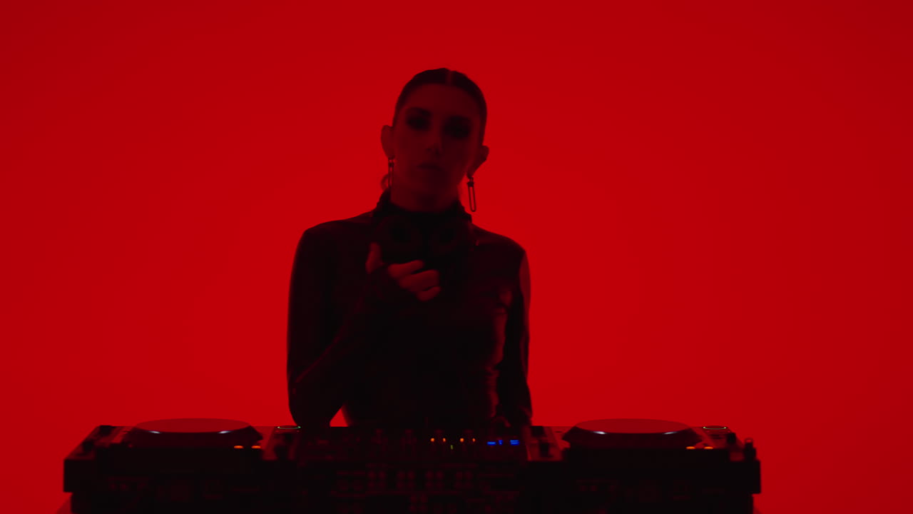 dj femenina en luz roja mezclando música