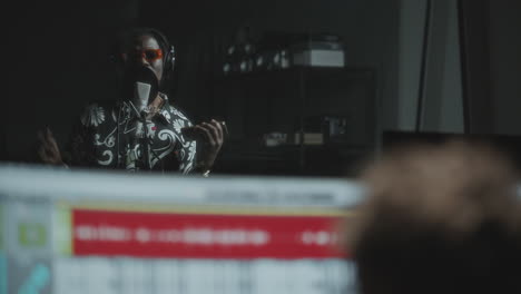 black rapper singing in recording studio with microphone and headphones