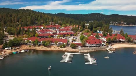 aerial panning shot across unique mountain village along a lake. 4k