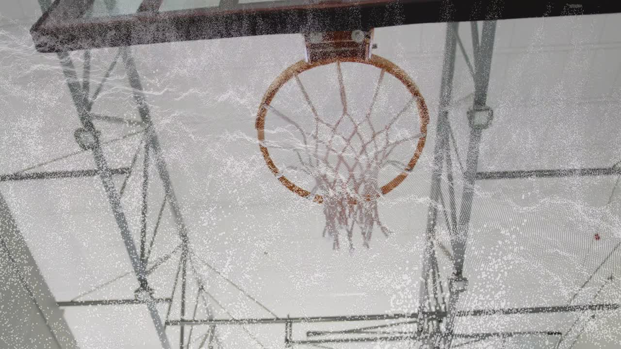 Braccio di un giocatore che entra nell'inquadratura spingendo il pallone verso il canestro, forzando una schiacciata, con la retina che ondeggia sotto la struttura di sostegno in un contesto sportivo.