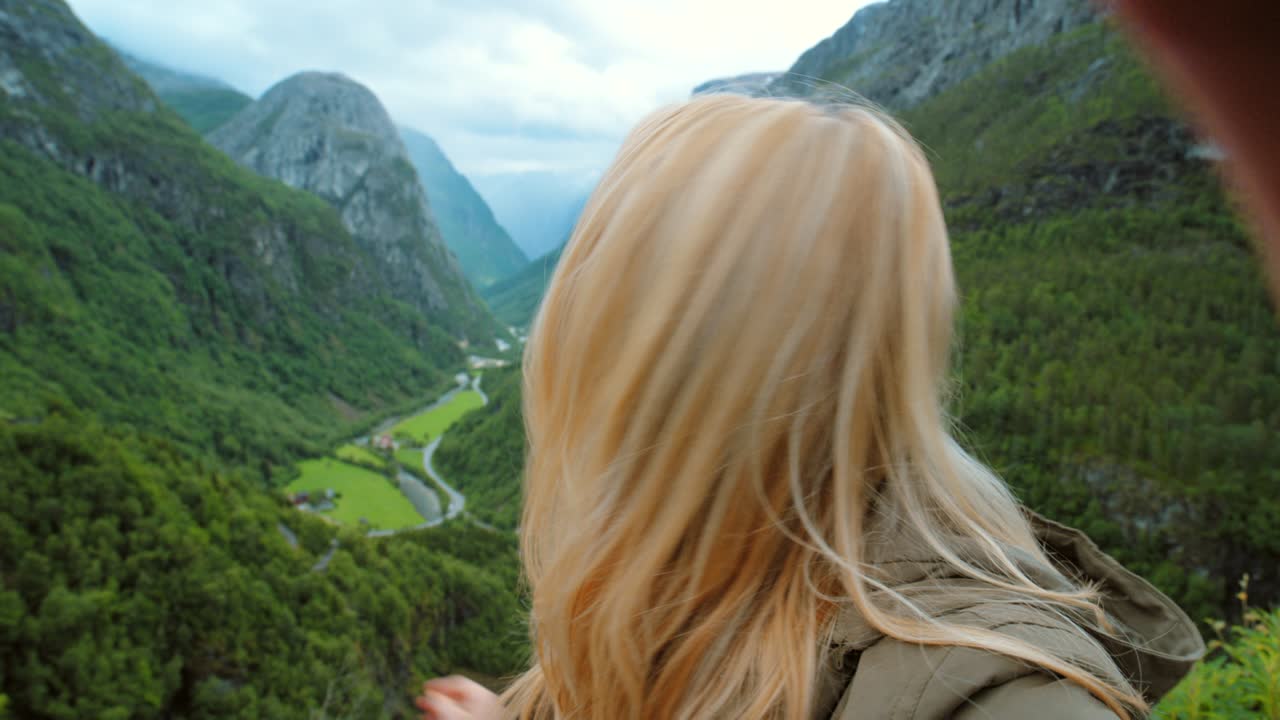 4k 영상: 매력적인 젊은 여성이 네로이달렌 계곡에서 하이킹하는 동안 영상을 녹음합니다.