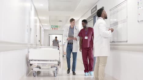 serious diverse male nurse and doctor with tablet walking in slow motion, unaltered