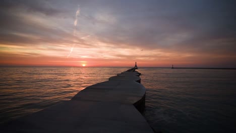 sunrise featuring the port washington wisconsin lighthouse, breakwater and birds