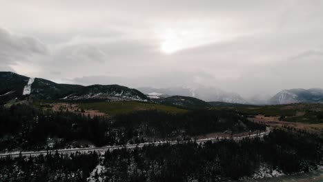 Vista-Aérea-De-Un-Dron-Nublado-Y-Cambiante-De-La-Carretera-De-La-Montaña-Del-Cisne-En-La-Ladera-Y-El-Banco-Del-Brazo-Del-Río-Serpiente-Cerca-Del-Embalse-Dillon-Del-Punto-De-Zafiro,-Colorado