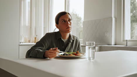 woman eating lunch in a modern kitchen