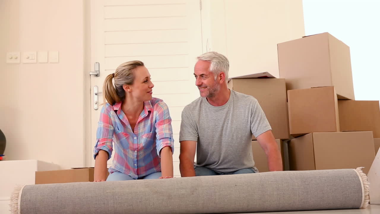 Happy couple rolling out a rug