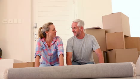 happy couple rolling out a rug