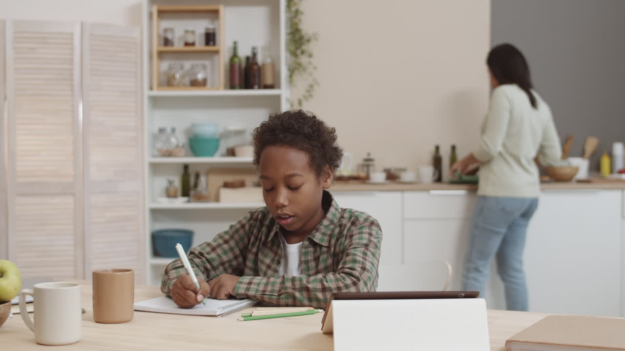 niño haciendo la tarea en la cocina