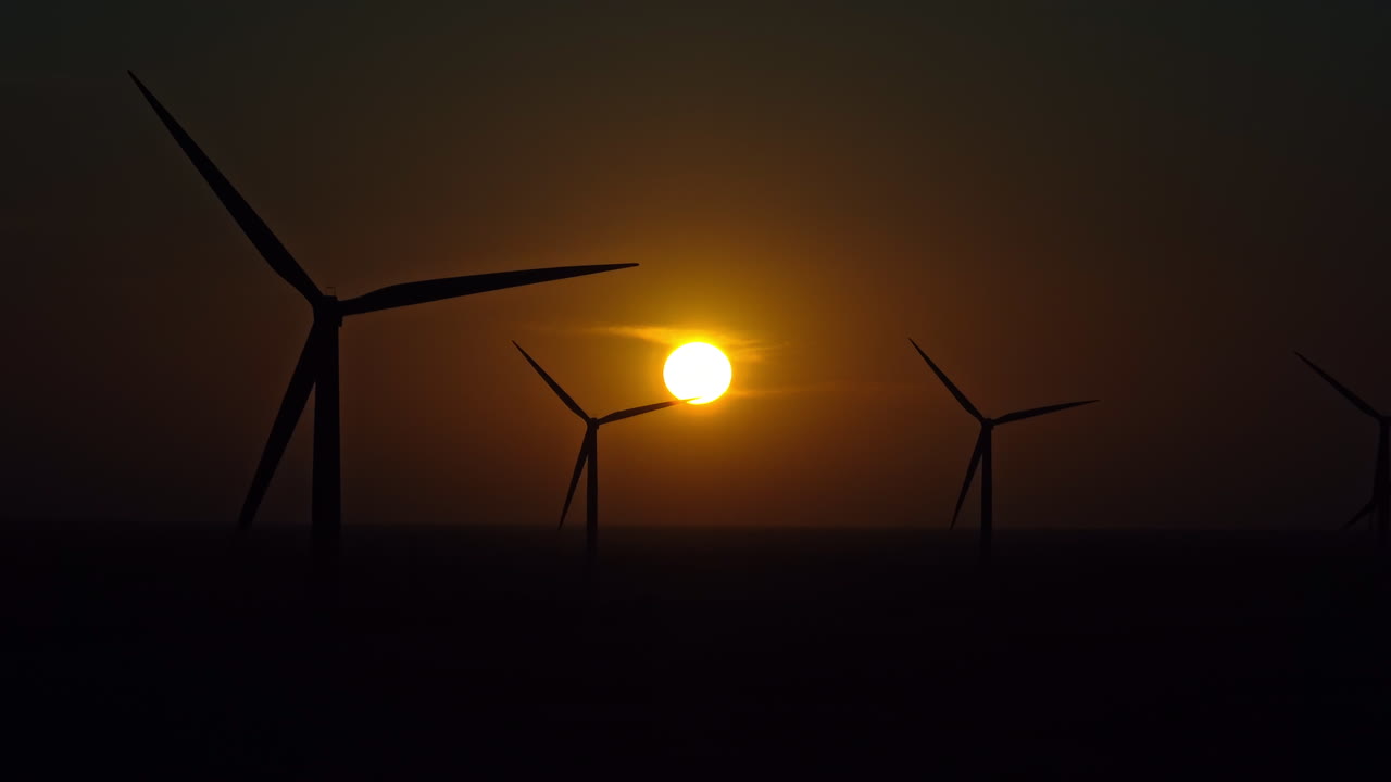 Silhouettes of wind turbines during a windy sunset in Brazil