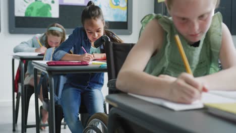 video de una colegiala caucásica en silla de ruedas en un escritorio trabajando en diversas clases, espacio de copia