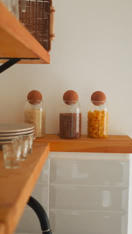 shelf with kitchen utensils in glamping hotel room. household goods on well-organized wooden shelves for comfortable stay. available to use for guests