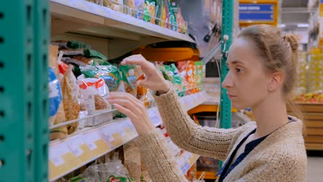 mujer comprando frutas secas en el supermercado