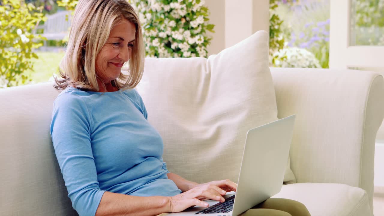 Senior woman using laptop in living room