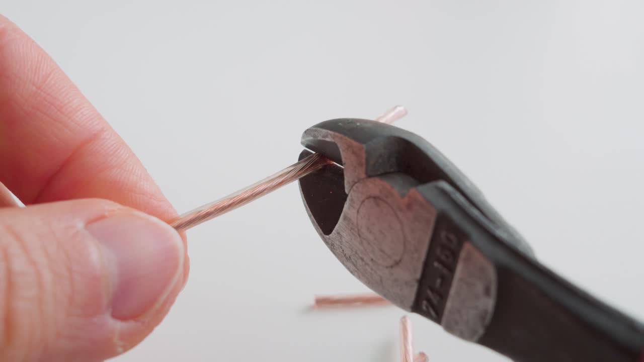 전선 절단기로 전기 와이어를 절단하는 사람