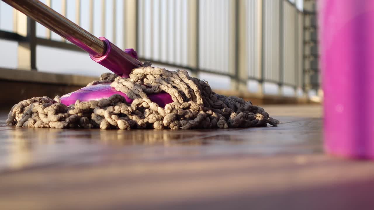 Close-up of a mop and bucket cleaning a floor