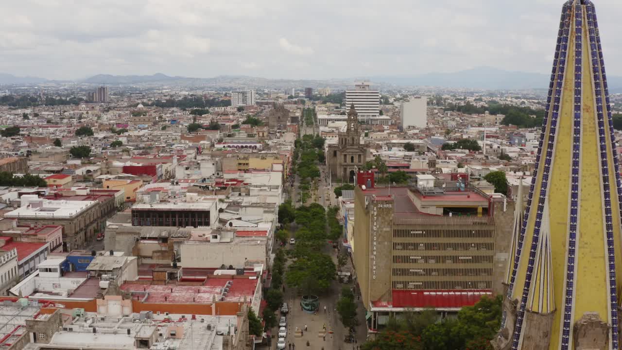 Drone view, south to north of the Fray Antonio Alcalde avenue and the metropolitan cathedral in downtown Guadalajara, Jalisco, Mexico.