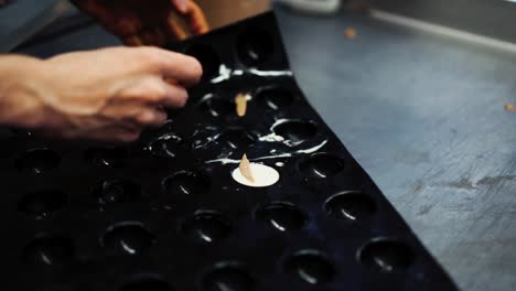 Close-up-shot-of-baker-taking-out-white-cookies-from-non-stick-baking-tray-in-slow-motion