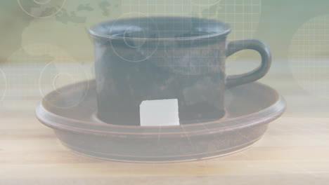 rustic dark brown ceramic cup being displayed on wooden surface, white sugar cube resting on saucer