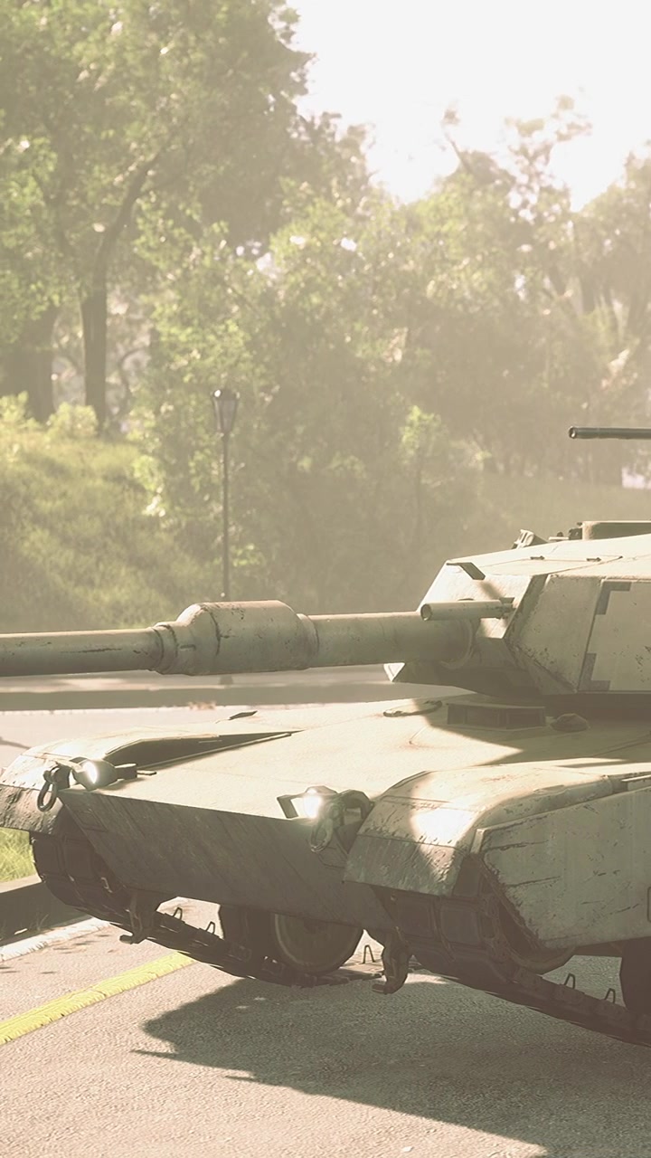 Military tank drives on a road near trees during daylight hours in a rural area