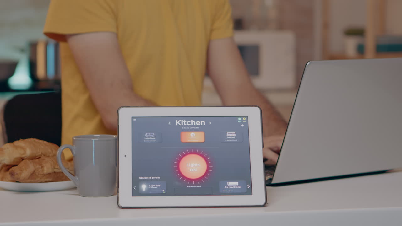 Male typing on laptop working from home with automation lighting system