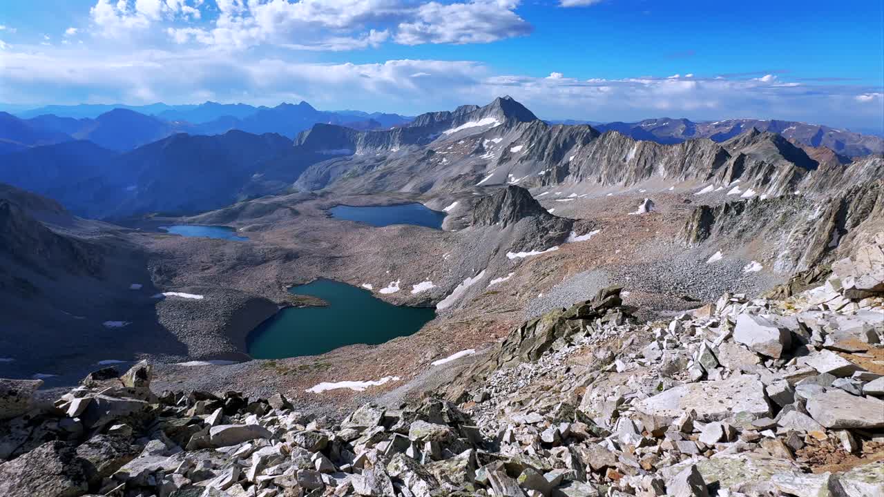 Capitol Peak 14er Wilderness high alpine elevation Rocky Mountains Colorado aerial drone Maroon Bells Peaks Mount Snowmass Knifes Edge Ridge Pierre Lakes summer early morning blue sky cloudy static