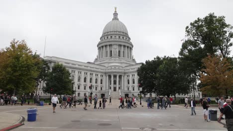 wisconsin state capitol building in madison, wisconsin and group of people on grounds with gimbal video walking forward.