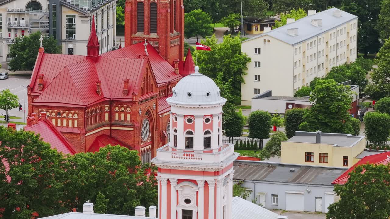 Art museum, red brick church in Jelgava with trees, urban rooftops, drone view