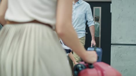 Caucasian-family-of-four-packing-luggage-into-car-trunk-for-holiday