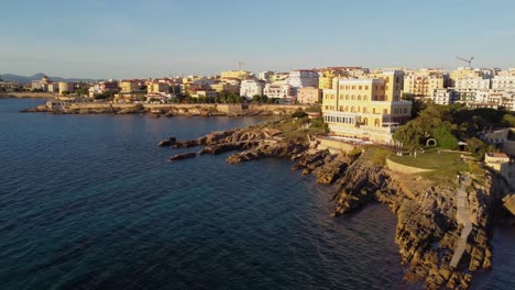 bella toma aérea sobre la antigua ciudad costera de alghero en italia al atardecer