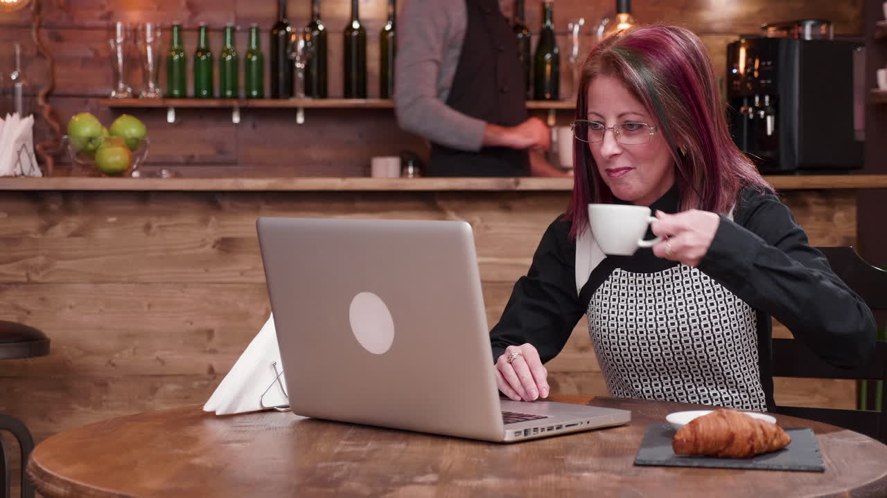 Kvinde der bruger bærbar computer på café