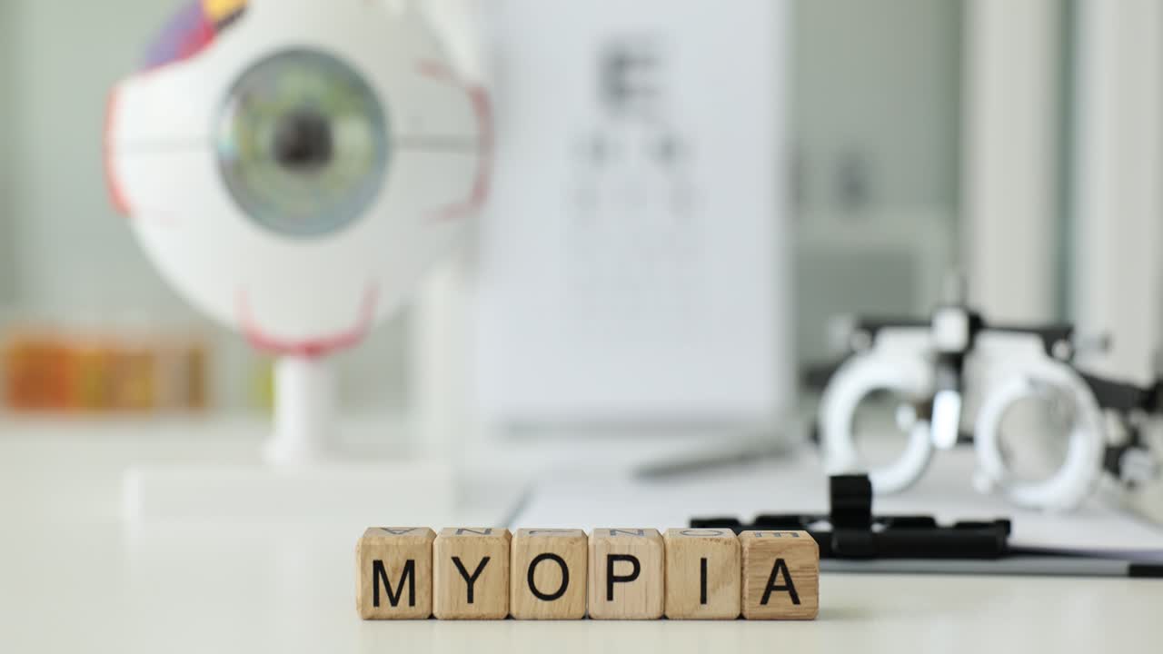 Word myopia from wooden blocks against glasses and eyeball