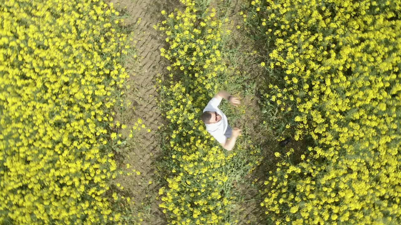 A man rapping in a vibrant rapeseed field in Ireland, enjoying an energetic moment